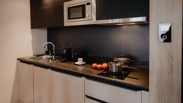 A modern kitchen with a microwave, sink, and stove.