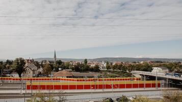 Una stazione ferroviaria con binari, un ponte e edifici circostanti.