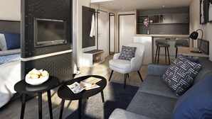 Una sala de estar moderna con un sofá gris, una mesa de centro negra con revistas, un sillón gris y un mueble de TV negro.
