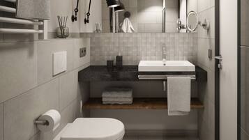 Un baño moderno con inodoro, lavamanos y espejo. Hay un perchero, una toalla y un estante con toallas.