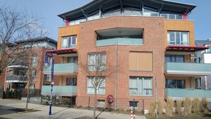 A multi-story residential building with balconies, a brick facade, and a flat roof. - Privatunterkunft AARON (Magdeburg)