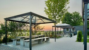 A covered outdoor area with benches and a small structure, surrounded by trees and a paved walkway. - Hotel City Inn Magdeburg (Magdeburg)
