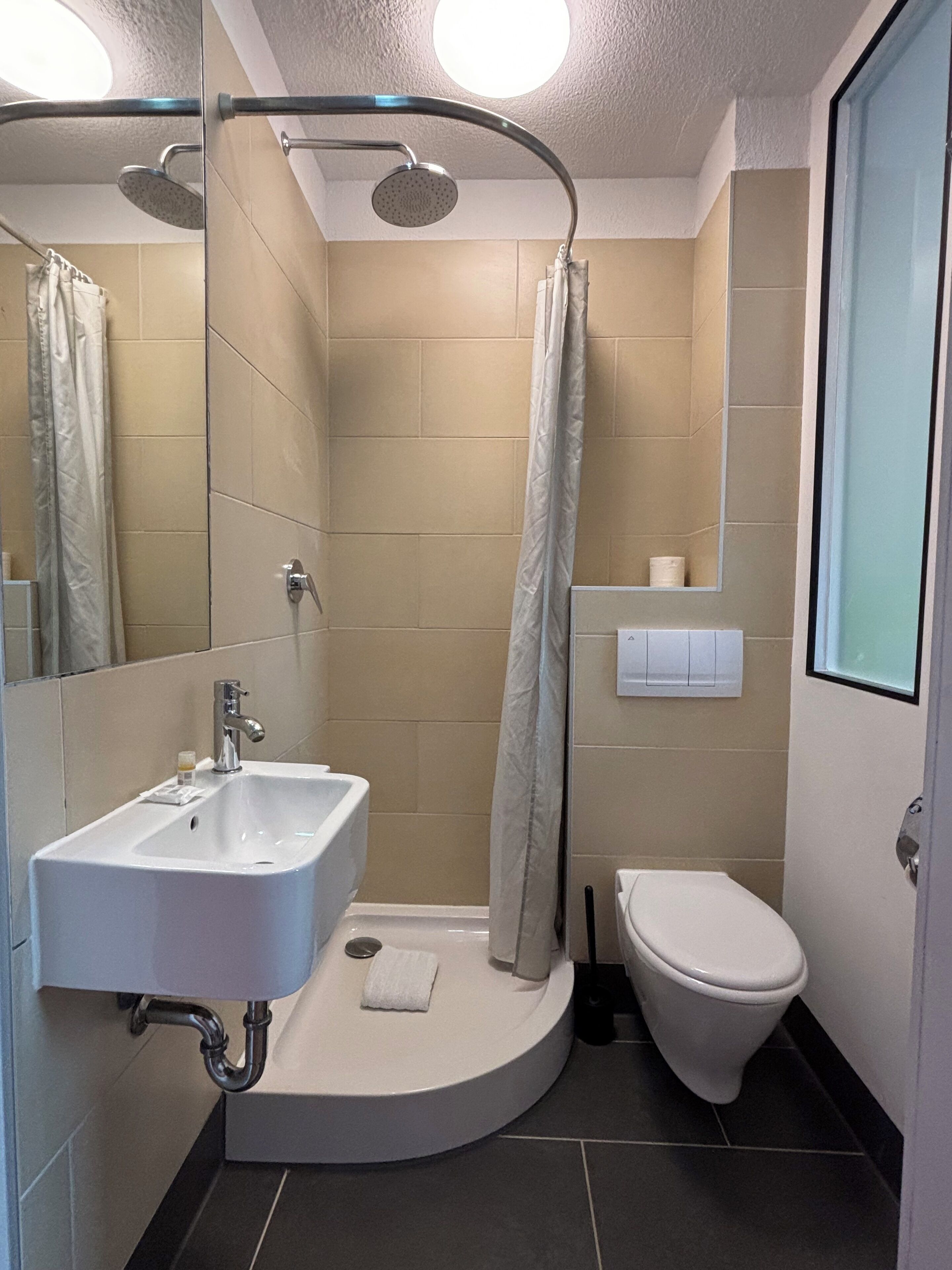 Ein modernes Badezimmer mit Dusche, Waschbecken und Toilette.