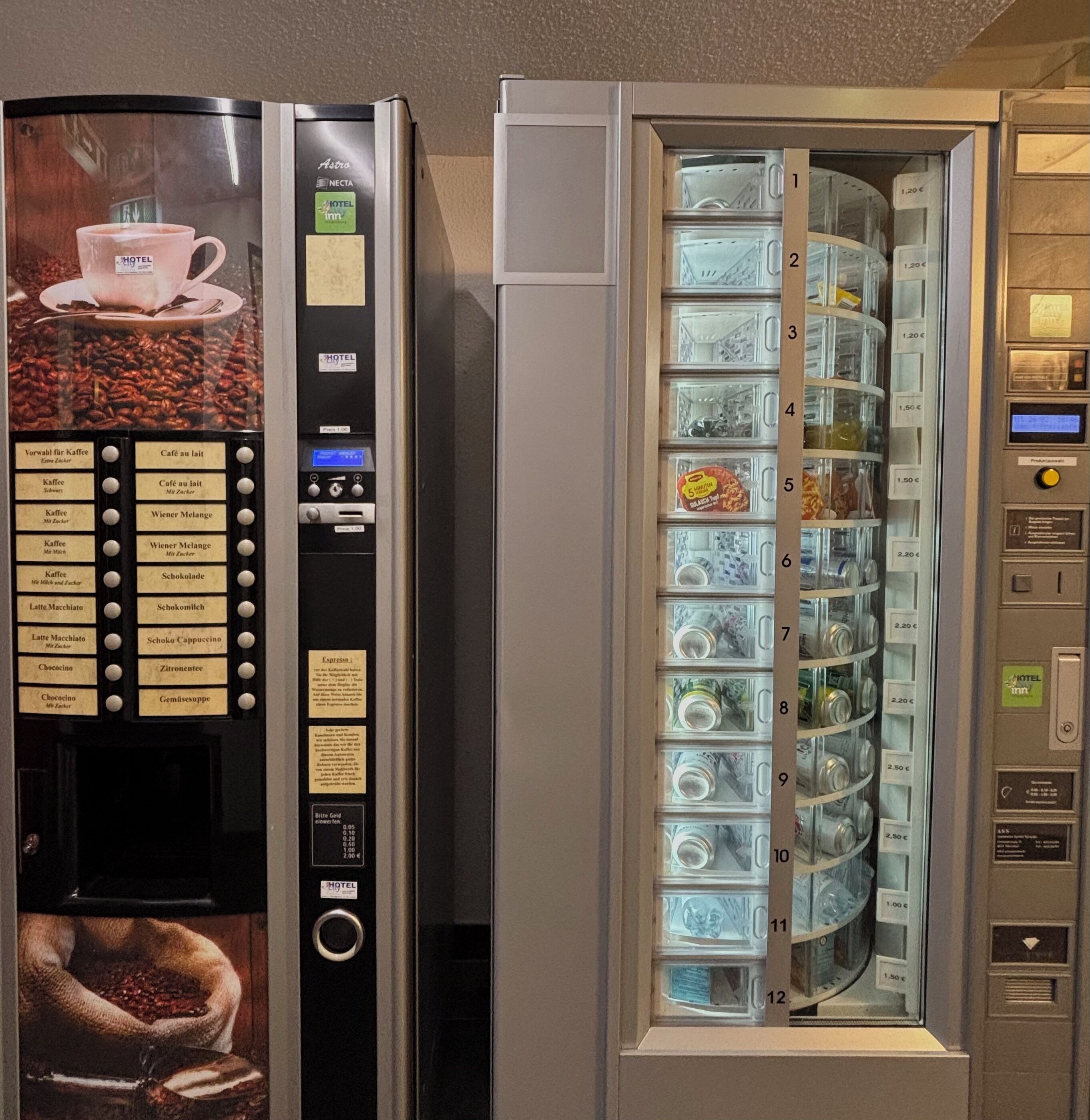 A coffee vending machine with a coffee cup and menu options, and a beverage dispenser with various drink options and prices.