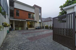 A modern two-story house with a paved driveway and a gated entrance. - Sans Vibes Jasmine Suite TB Simatupang (Jakarta)