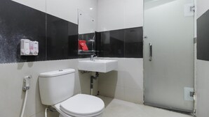 Un baño pequeño y moderno con inodoro, lavabo y ducha.
