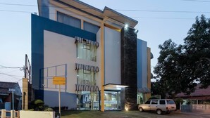 Un edificio moderno con techo plano, amplias ventanas y una entrada visible con puerta de vidrio.