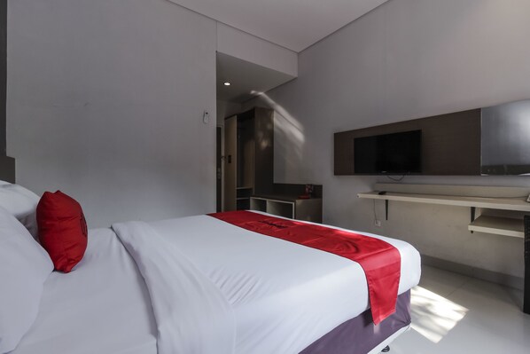 Habitació d'hotel moderna amb un llit, un escriptori i una televisió.