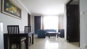 Un salón comedor espacioso, un cuadro grande en la pared y vistas a través de una ventana.