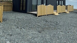 En moderne bygning med store vinduer og en træterrasse.