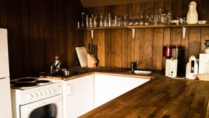 Une cuisine avec des meubles de rangement en bois, une cuisinière blanche, un évier et un plan de travail.