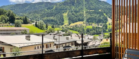 A balcony with a view of a mountain and a village.