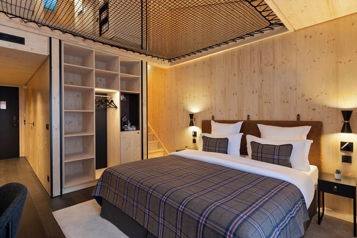 Un dormitorio con cama, armario y escalera.