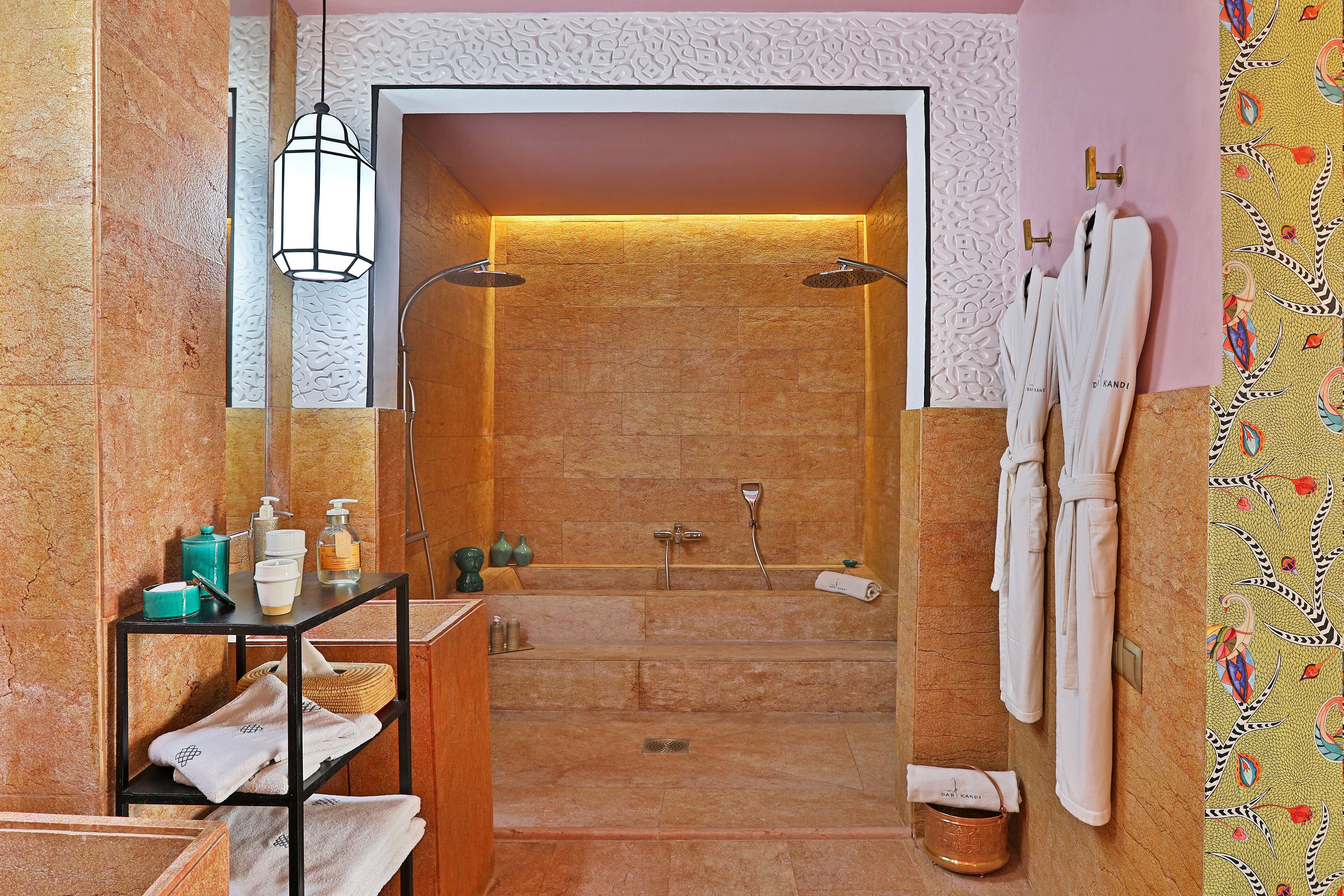 Une salle de bain moderne avec une douche à parois de verre, un meuble-lavabo avec des articles de toilette et un porte-serviettes.