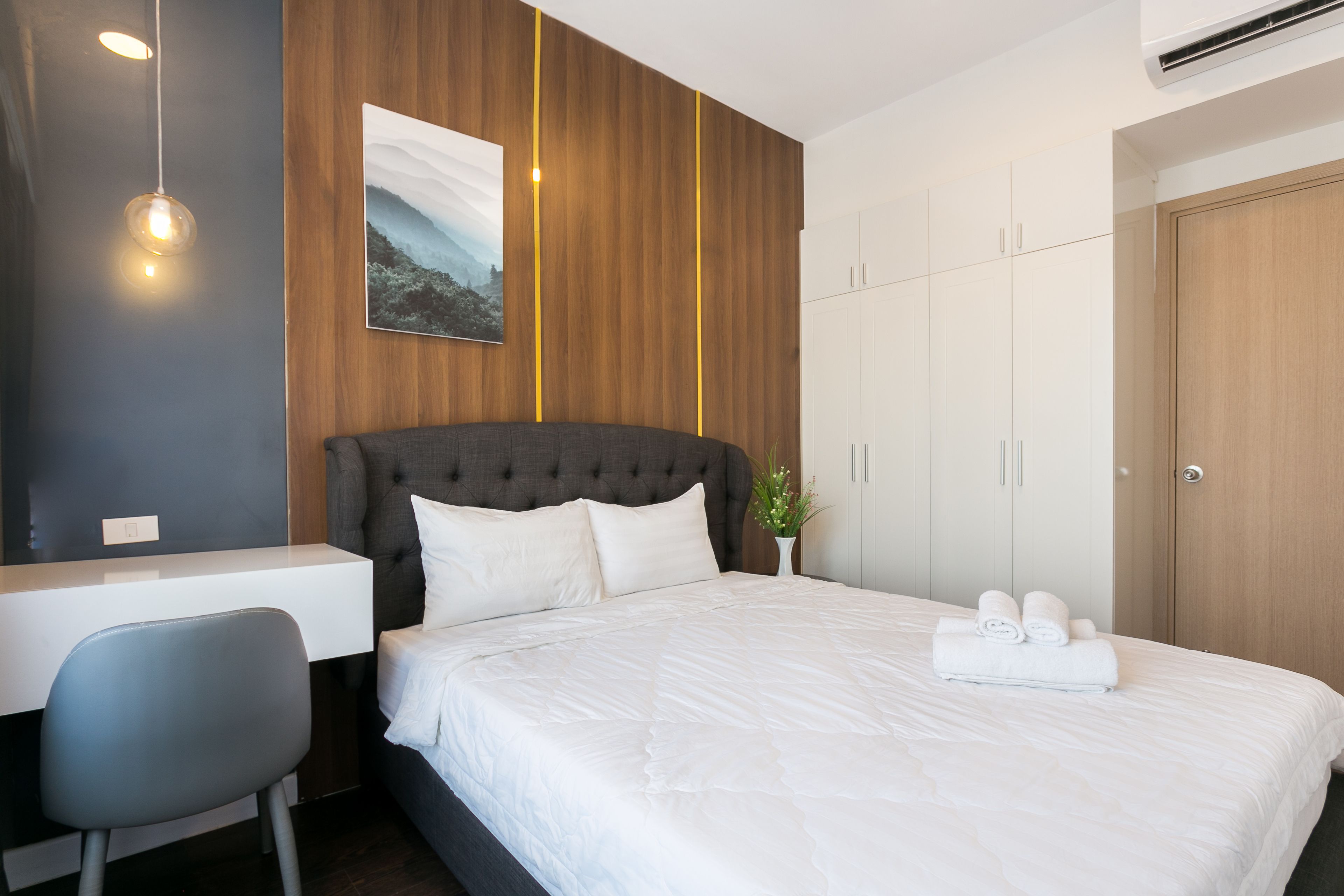 Une chambre d’hôtel moderne, dotée d’un grand lit, d’un bureau et d’une armoire.