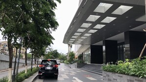 A black SUV parked on a paved road with a modern building in the background. - Saigon Apartment - RiverGate Residence (Ho Chi Minh City)