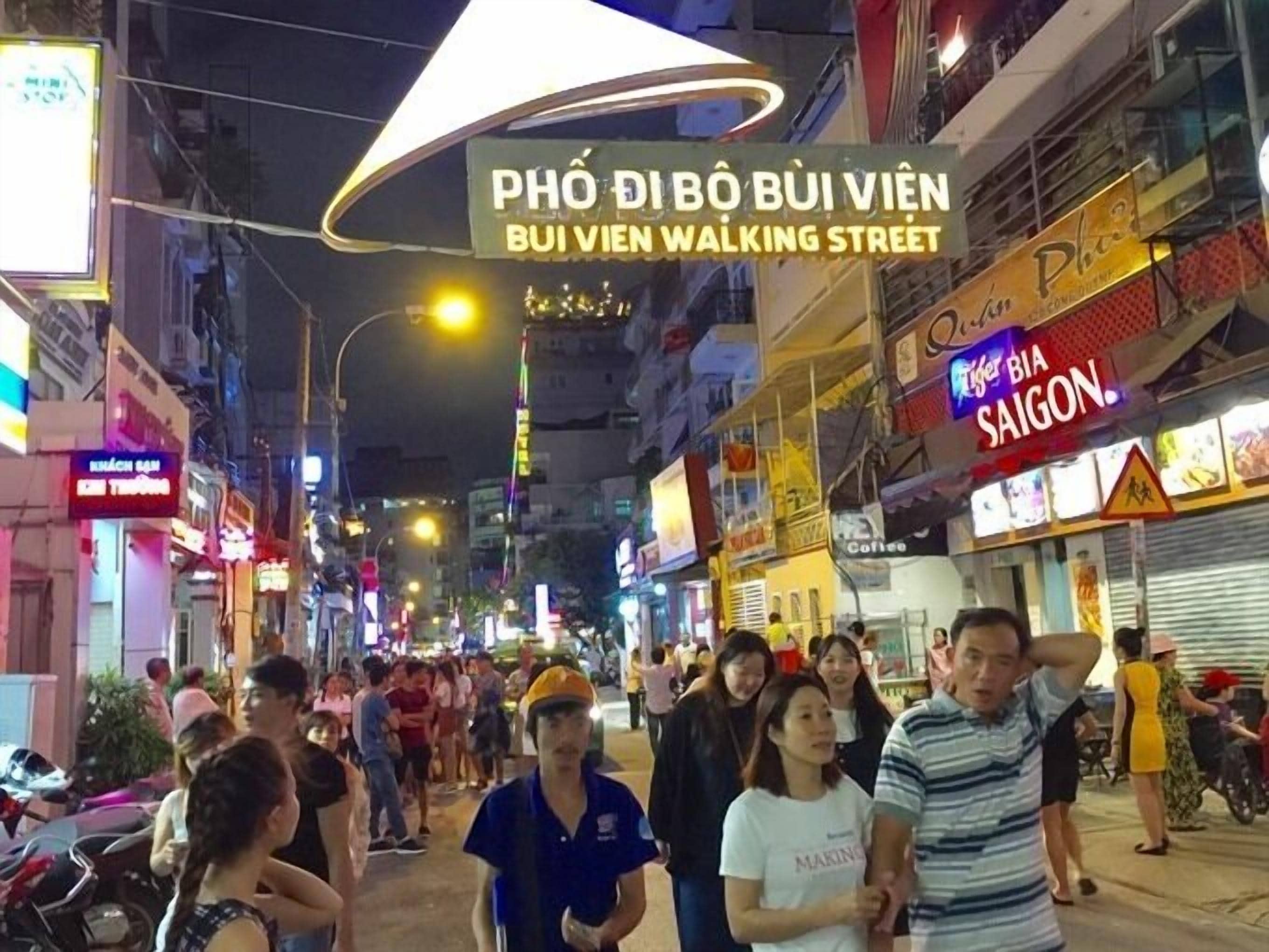 A busy street with various shops and signs, including one for 'BUI VIEN WALKING STREET'.