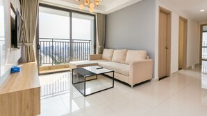 A modern living room with a sofa, a coffee table, and a TV. - Saigon Apartment - RiverGate Residence (Ho Chi Minh City)