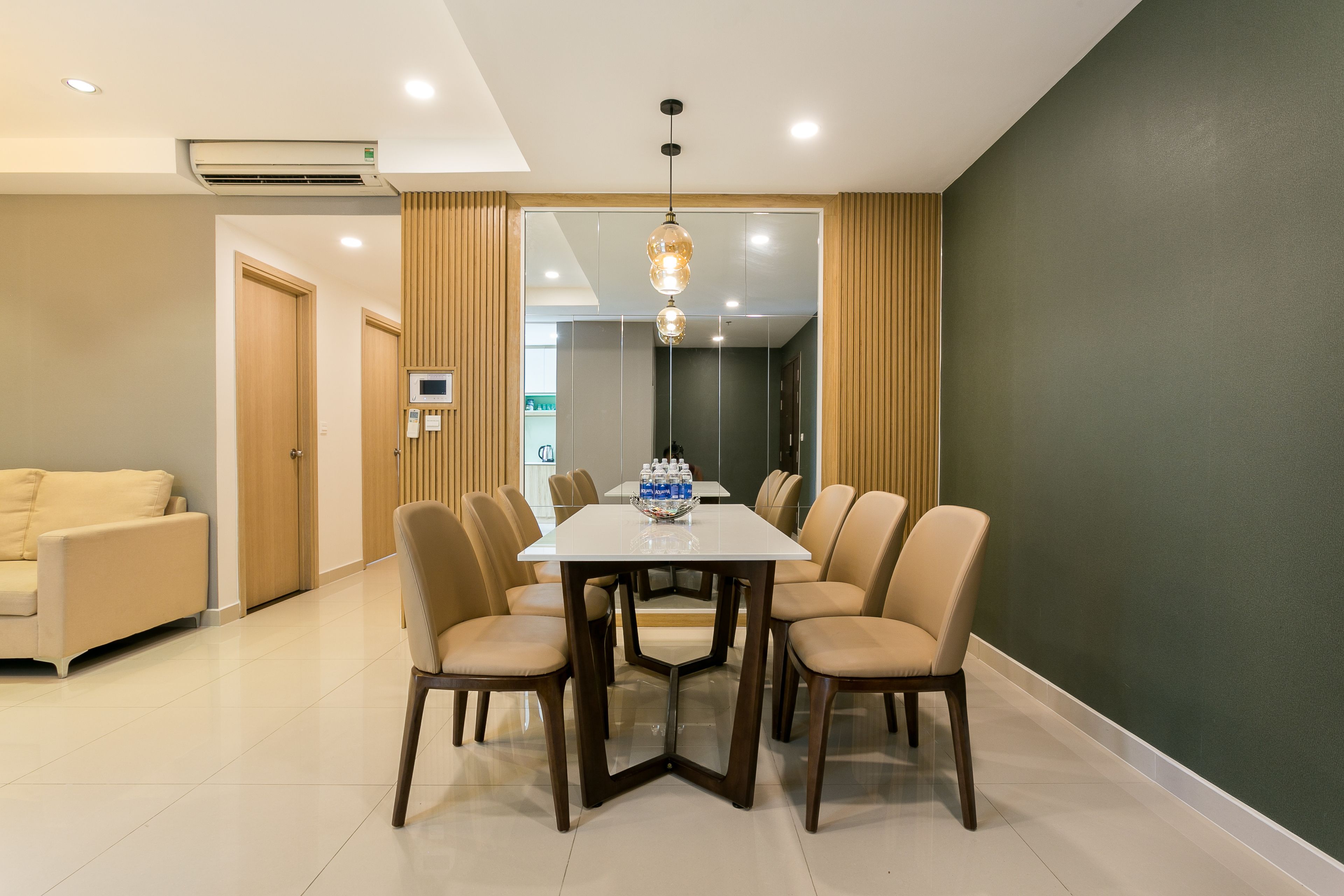 A modern dining area with a rectangular table, six chairs, and a chandelier.
