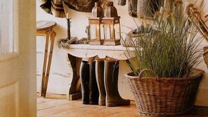 A rustic interior with wooden shelves displaying coats, a lantern, and a wicker basket. - Fish Creek House Bed & Breakfast (Whitehall)