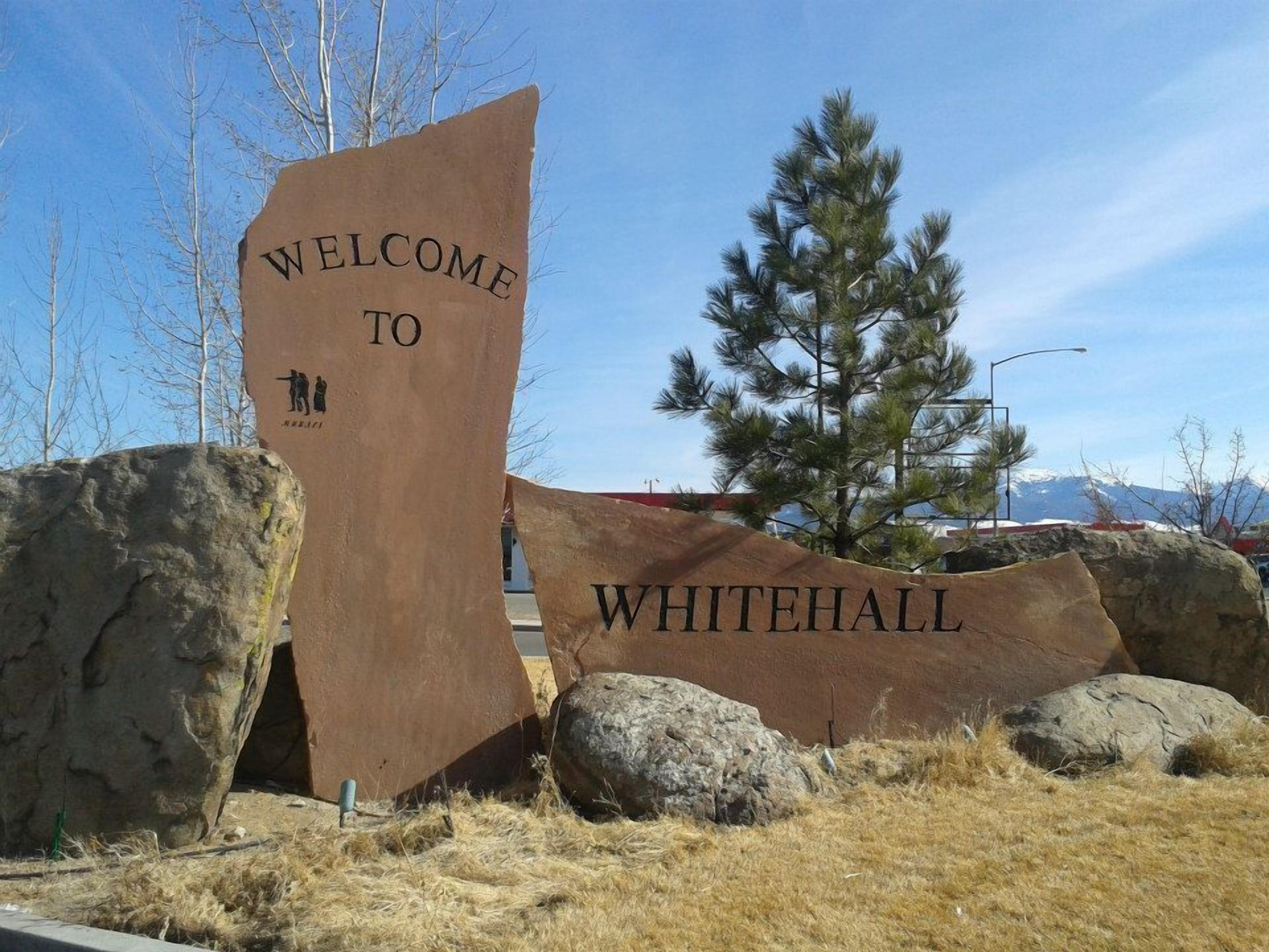 A welcome sign for Whitehall with a rugged, natural backdrop.