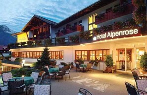 Hotel Alpenrose con terraza al aire libre y un paisaje de montaña.