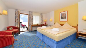 Une chambre d’hôtel avec un lit, un bureau, une chaise et une vue sur l’extérieur.