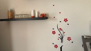 A room with two black shelves against the wall, each holding various items. - B&B Tre Passi Dalla Torre (Montesarchio)