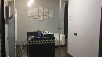 Un moderno spazio ufficio con cubili, una parete divisoria in vetro e opere d'arte alle pareti.
