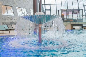 Una piscina interior con una fuente central.