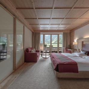 A hotel room with a bed, a sofa, a desk, and a view of the outdoors. - Aqua Dome Therme (Laengenfeld)