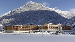 A hotel with a modern design, a large building with multiple floors, and a view of snow-covered mountains in the background. - Aqua Dome Therme (Laengenfeld)