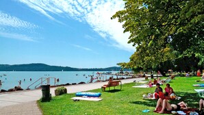 A lakeside park with grassy areas, picnic tables, and a walking path. - Happy Camp mobile homes in Füred Camping (Balatonfured)