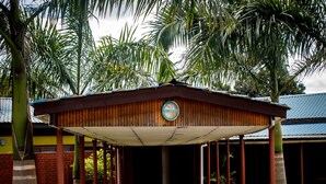 A covered outdoor area with a concrete pathway leading to a building with a blue roof. - Dream Valley Park & Lodge (Lusaka)