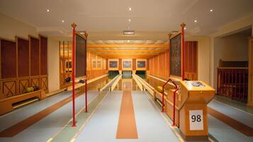 Un hall d’hôtel avec un couloir central, des lambris en bois et une enseigne portant le numéro 98.
