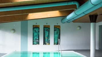 Una piscina techada, sillones reclinables de piscina