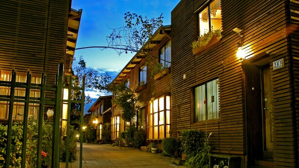 Uma fileira de casas de madeira com janelas grandes e o número 283 no lado direito.