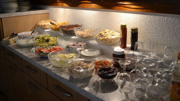A buffet table with various dishes and beverages.