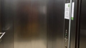 An elevator with metallic doors and a control panel with a green button. - SleepySleepy Hotel Dillingen (Dillingen an der Donau)