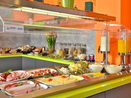A buffet with various food items and a juice dispenser.