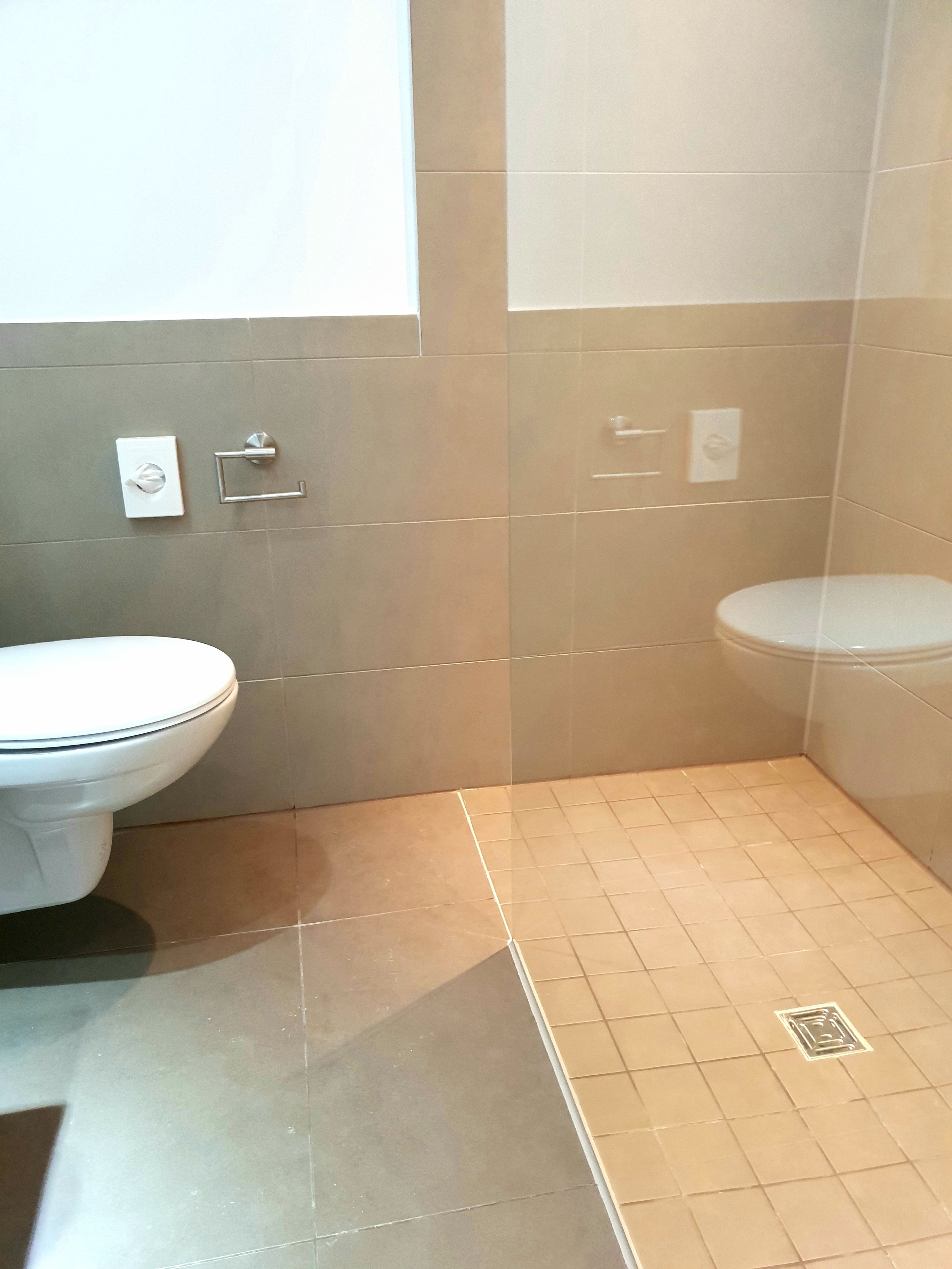 A bathroom with a toilet, a sink, and a shower area.