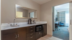 Een moderne hotelbadkamer met een wastafel, spiegel en magnetron.