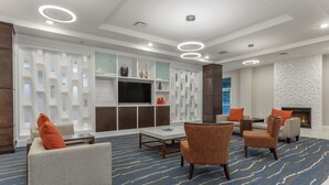 A modern lounge area with sofas, a coffee table, and a flat-screen TV. - Holiday Inn Hotel & Suites Jefferson City by IHG (Jefferson City)