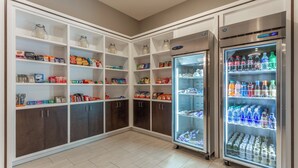 A self-service snack and drink station with refrigerated and non-refrigerated options, including a variety of snacks, beverages, and bottled water. - Holiday Inn Hotel & Suites Jefferson City by IHG (Jefferson City)