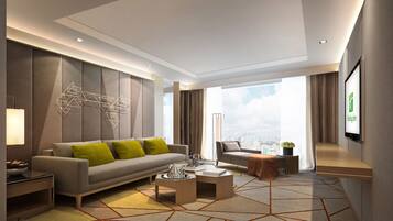 Quarto de hotel moderno com sofá, poltrona, mesa de centro e vista para a cidade através de grandes janelas.