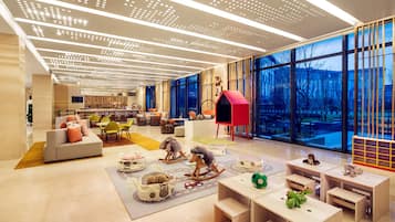 Children can play and relax in this vibrant play area with a sofa, rocking horse, and tables.