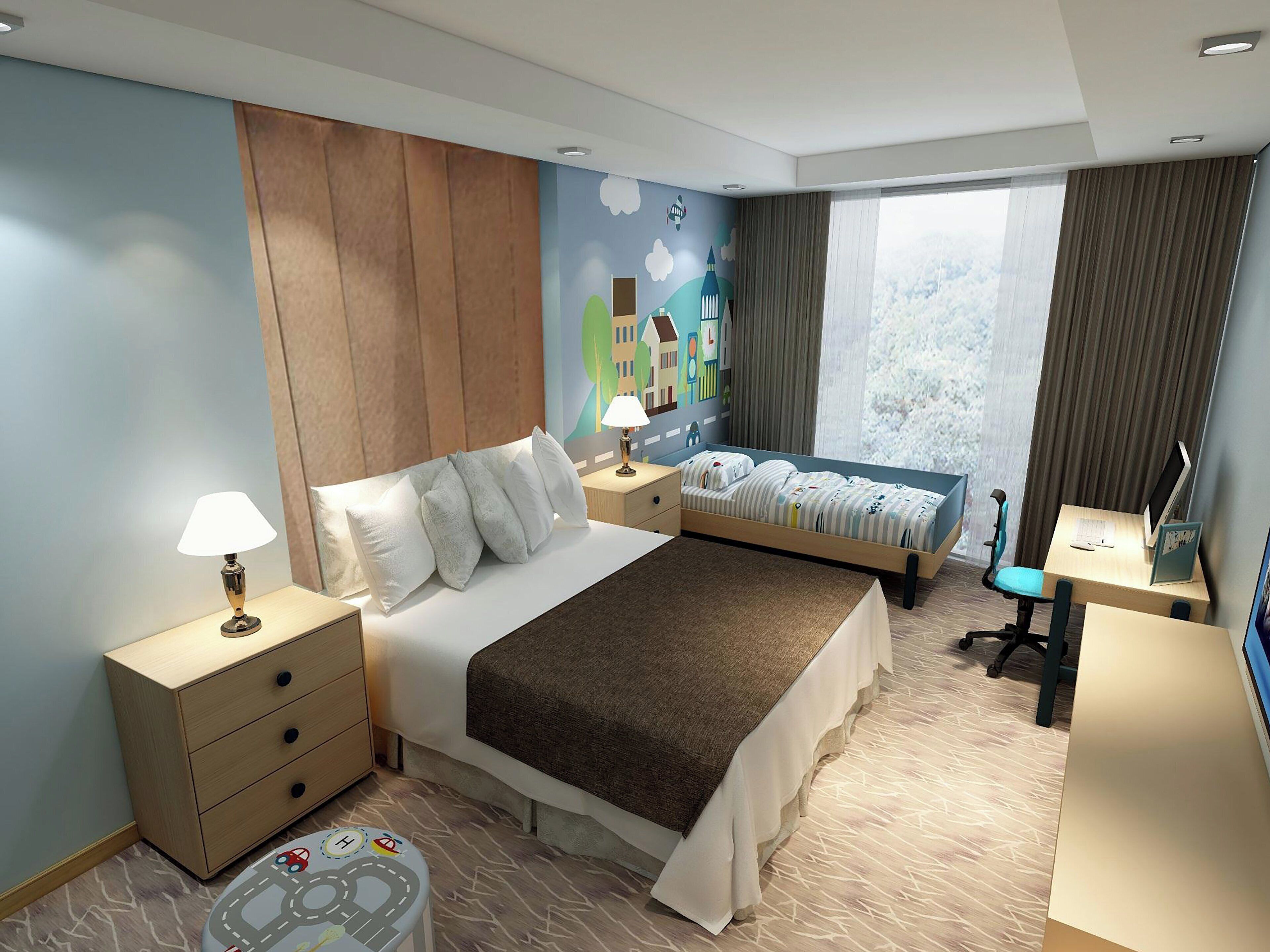 A hotel room with a bed, bedside table, lamp, desk, chair, and a view of the outdoors.