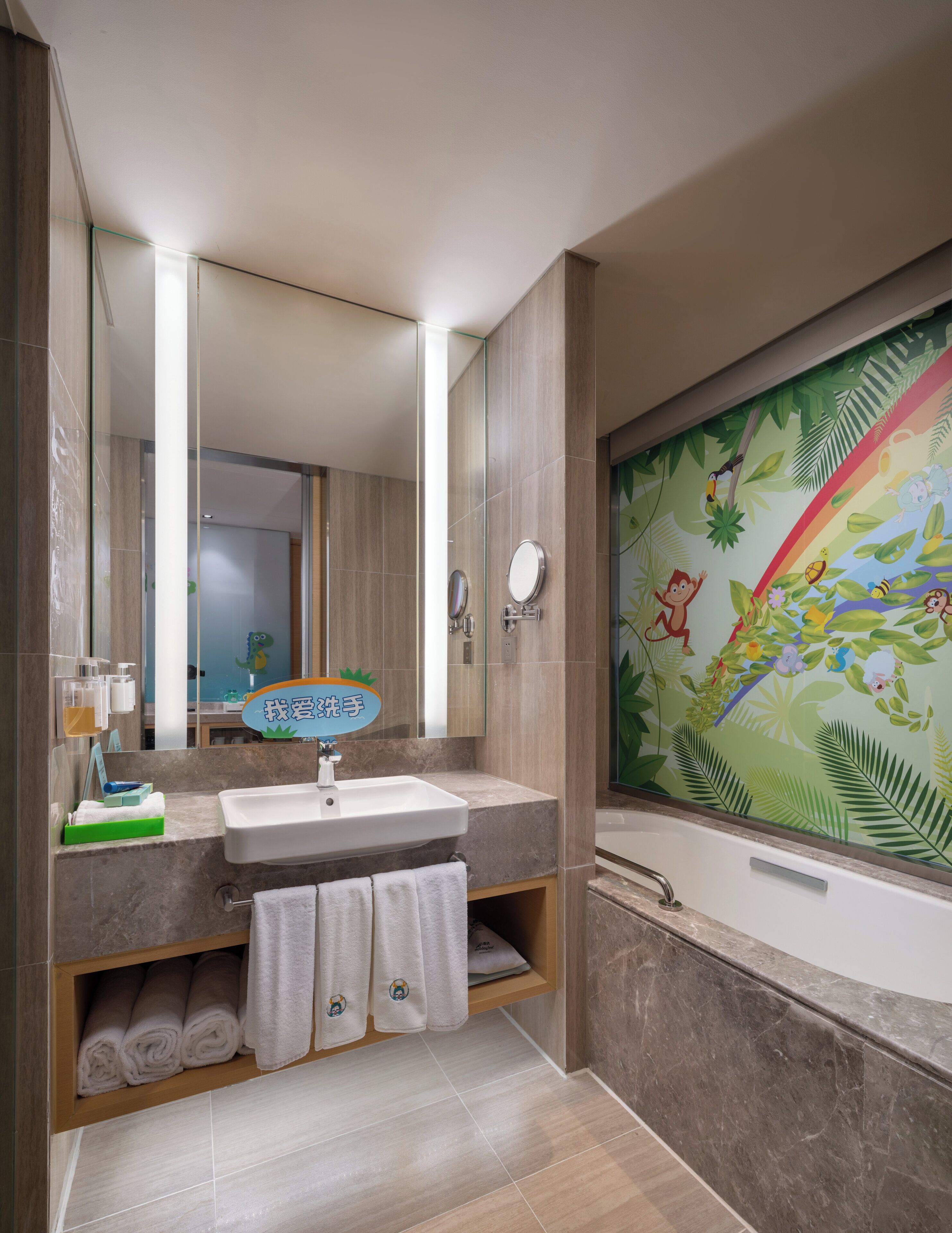Un baño moderno con un espejo grande, un lavabo, una bañera y un mural en la pared.