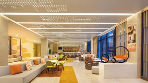 Un intérieur moderne avec un espace salon central, un bar et une grande fenêtre offrant une vue.