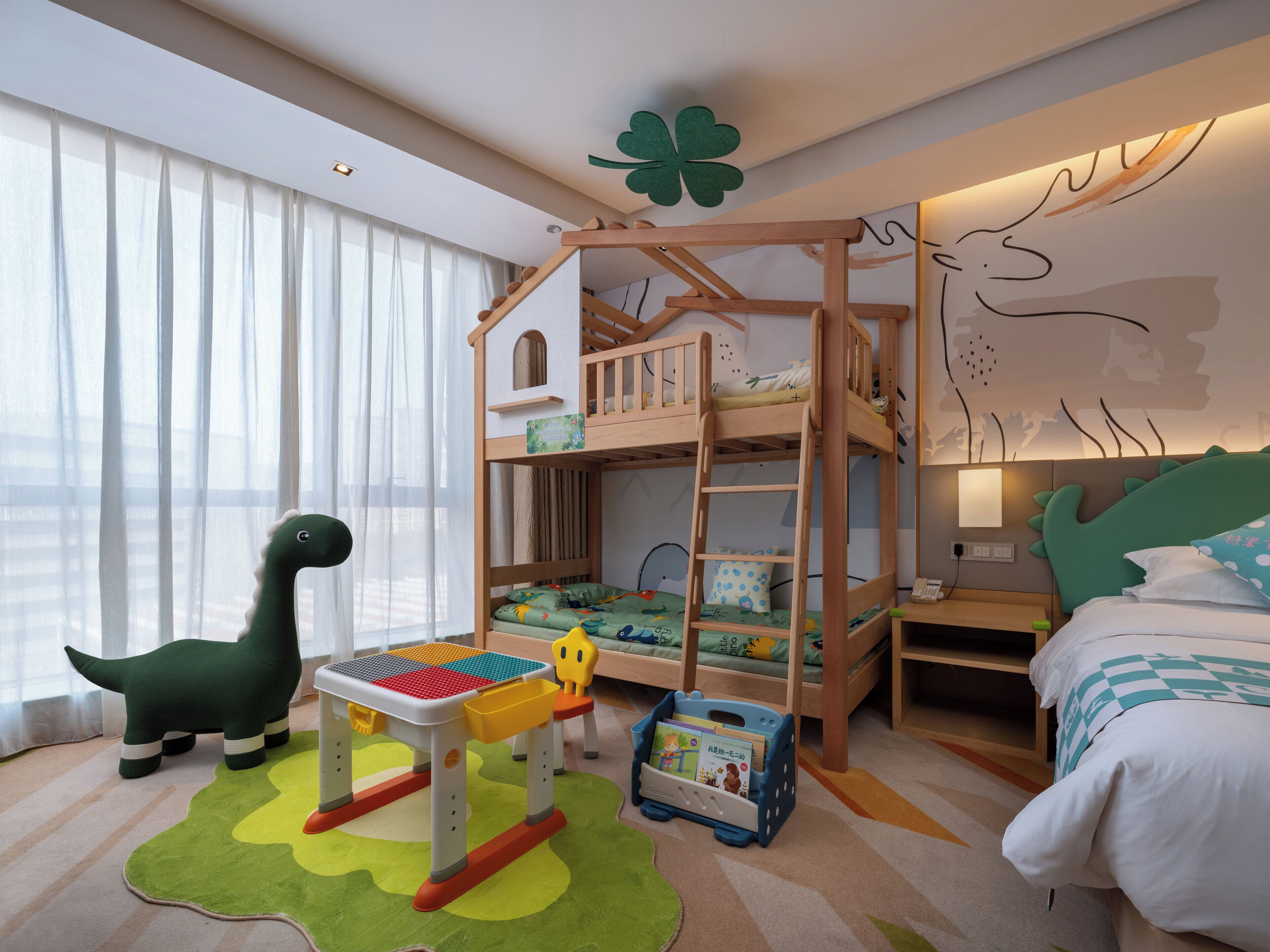 A child's bedroom with bunk beds, a play table, and a dinosaur toy.